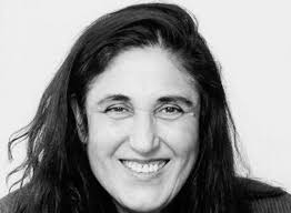 Photo en noir et blanc de l'auteure Emine Sevgi Özdamar un grand sourire illuminant son visage