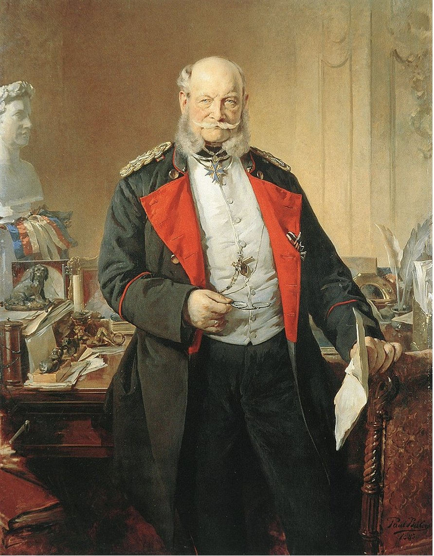 Portrait de Guillaume Ier dans son cabinet de travail. L'Empereur nous regarde, tenant ses lunettes dans une main et des parchemins dans l'autre, qui repose sur le dossier d'un fauteuil