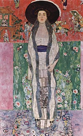Une femme au grand chapeau noir se tient debout, statique, et nous regarde. Ses vêtements sont simples, symétriques de droite à gauche. Au fond, des motifs asiatiques rouges et verts et un draps représentant des fleurs contrastent fortement.