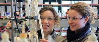 Photo représentant 2 jeunes filles souriantes en train d'expérimenter dans un laboratoire